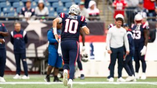 FOXBOROUGH, MASSACHUSETTS – SEPTEMBER 25: Quarterback Mac Jones #10 of the New England Patriots jogs towards the sideline after an injury during the fourth quarter against the Baltimore Ravens at Gillette Stadium on September 25, 2022 in Foxborough, Massachusetts. (Photo by Adam Glanzman/Getty Images)