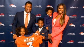 Quarterback Russell Wilson of the Denver Broncos poses with his family (L-R), Sienna, Future, Win and Ciara following an introductory press conference at UCHealth Training Center on March 16, 2022 in Englewood, Colo.