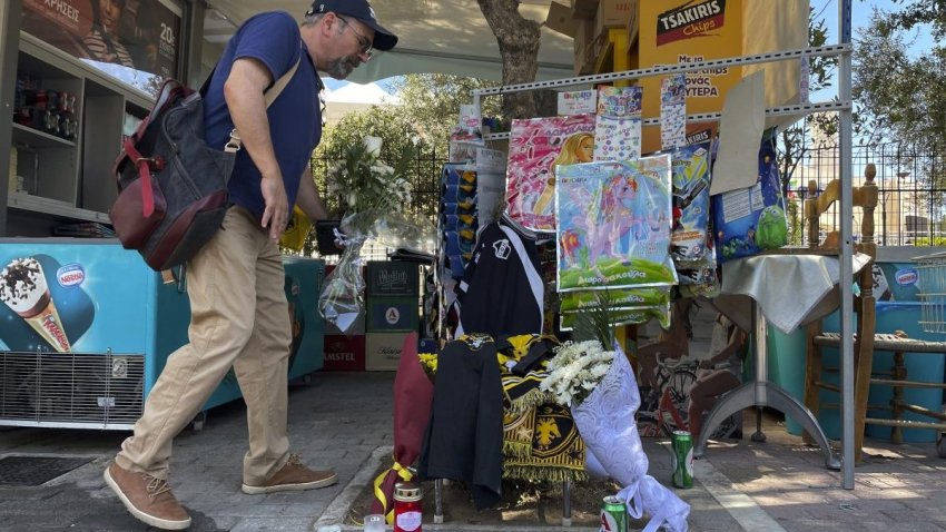 A man lays flowers, on the location where a 29-year-old Greek fan has died after overnight clashes between rival supporters in Nea Philadelphia suburb, in Athens, Greece, Tuesday, Aug. 8, 2023. European governing soccer body UEFA says it has postponed a Champions League qualifying game between AEK Athens and Croatia’s Dinamo Zagreb scheduled for Tuesday because of the violence. Eight fans were injured while Greek police said Tuesday they had made 88 arrests, mostly of Croatian supporters. (AP Photo/Thanassis Stavrakis)