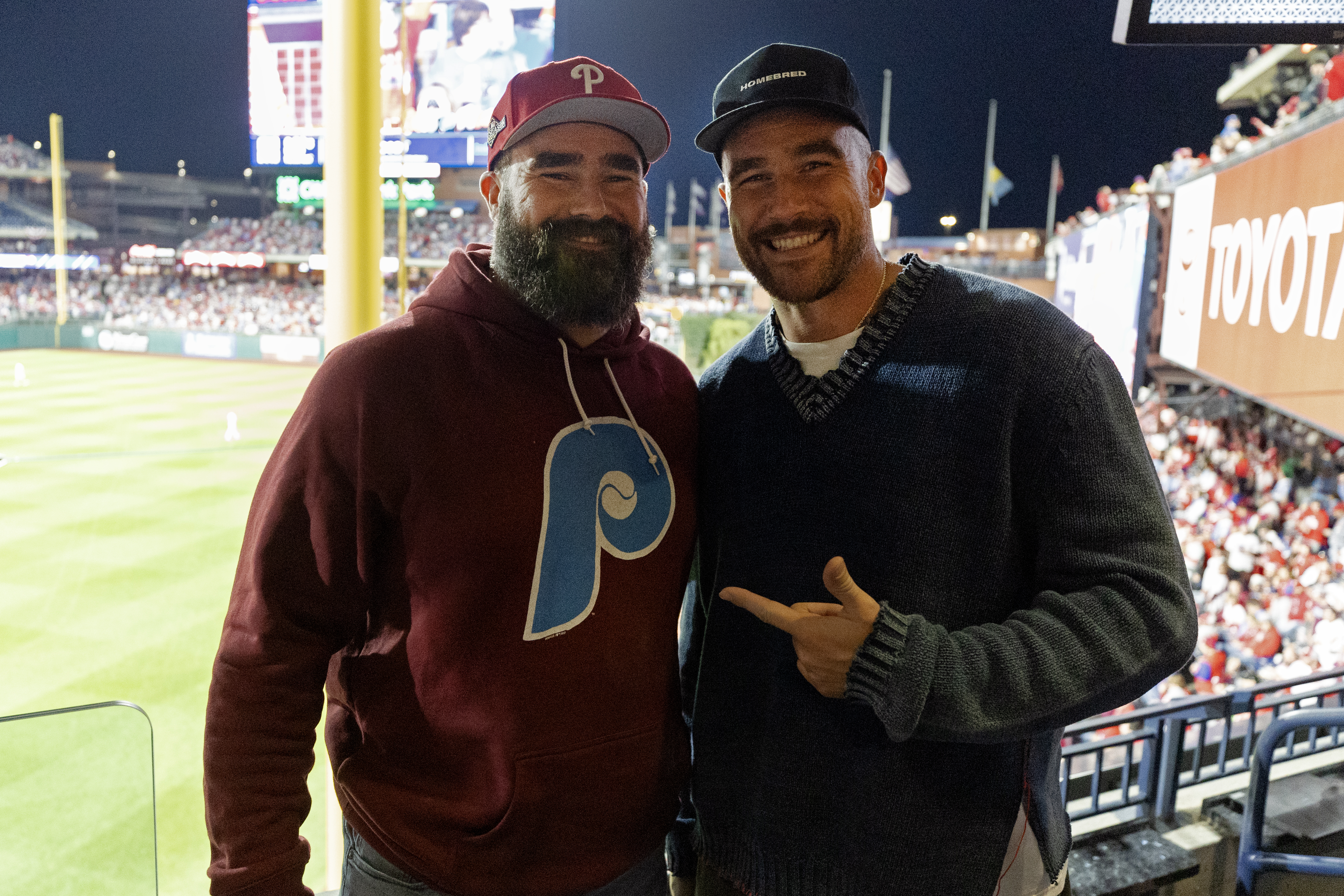 Speaking of Taylor Swift, Eagles star Jason Kelce and his brother Travis Kelce pose for a photo during Game 1 of the 2023 NLCS.