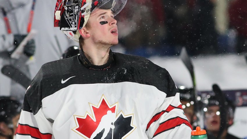 Carter Hart looks off into distance in Canada jersey.