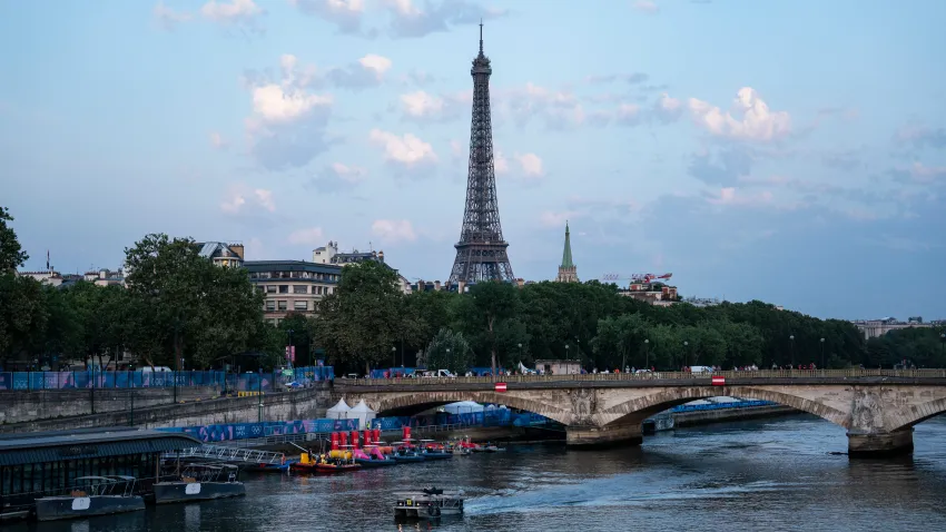 A boat floats down the Seine River at sunrise after the Men's triathlon race was postponed due to Seine pollution and high E.coli levels during the 2024 Summer Olympics, at the Pont Alexandre III bridge in Paris, France, on Tuesday, July 30, 2024.