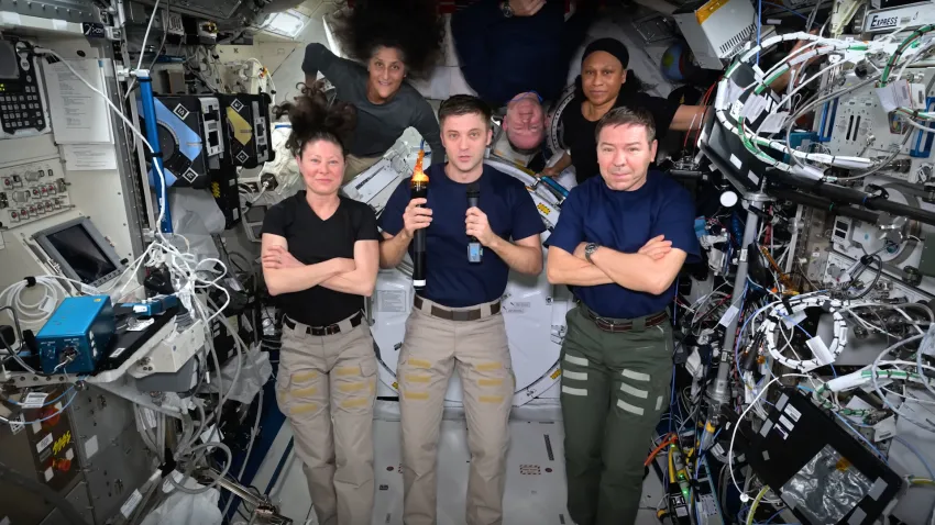 Astronauts aboard the ISS hold an Olympic torch