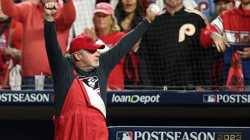 John Kruk holds up baseball in front of Phillies fans.