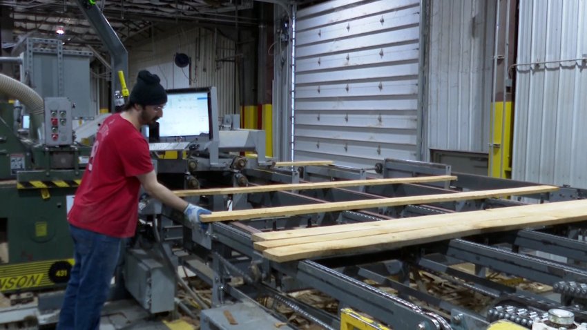 A man organizing wood in a factory.