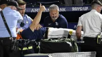 Tampa Bay Rays’ Hunter Bigge gives a thumbs up as paramedics tend to him after being hit by a foul ball while in the dugout during the seventh inning of a baseball game against the Baltimore Orioles, Thursday, June 19, 2025, in Tampa, Fla. (AP Photo/Jason Behnken)