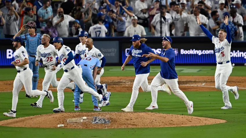 Los Angeles, CA – October 09:  Los Angeles Dodgers celebrate as they run past relief pitcher Orion Kerkering #50 of the Philadelphia Phillies after defeating the Phillies 2-1 in the eleventh inning of game 4 of a National League Division series baseball game at Dodger Stadium in Los Angeles on Thursday, October 9, 2025.  Los Angeles Dodgers won 2-1 to adavance to the NLCS. (Photo by Keith Birmingham/MediaNews Group/Pasadena Star-News via Getty Images)