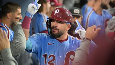 Oct 8, 2025; Los Angeles, California, USA; Philadelphia Phillies designated hitter Kyle Schwarber (12) celebrates in the dugout after hitting a solo home run during the fourth inning against the Los Angeles Dodgers during game three of the NLDS round for the 2025 MLB playoffs at Dodger Stadium. Mandatory Credit: Jayne Kamin-Oncea-Imagn Images