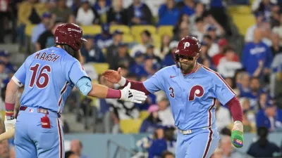 Oct 8, 2025; Los Angeles, California, USA; Philadelphia Phillies first baseman Bryce Harper (3) celebrates with Philadelphia Phillies center fielder Brandon Marsh (16) after scoring on a Los Angeles Dodgers throwing error during the fourth inning during game three of the NLDS round for the 2025 MLB playoffs at Dodger Stadium. Mandatory Credit: Jayne Kamin-Oncea-Imagn Images