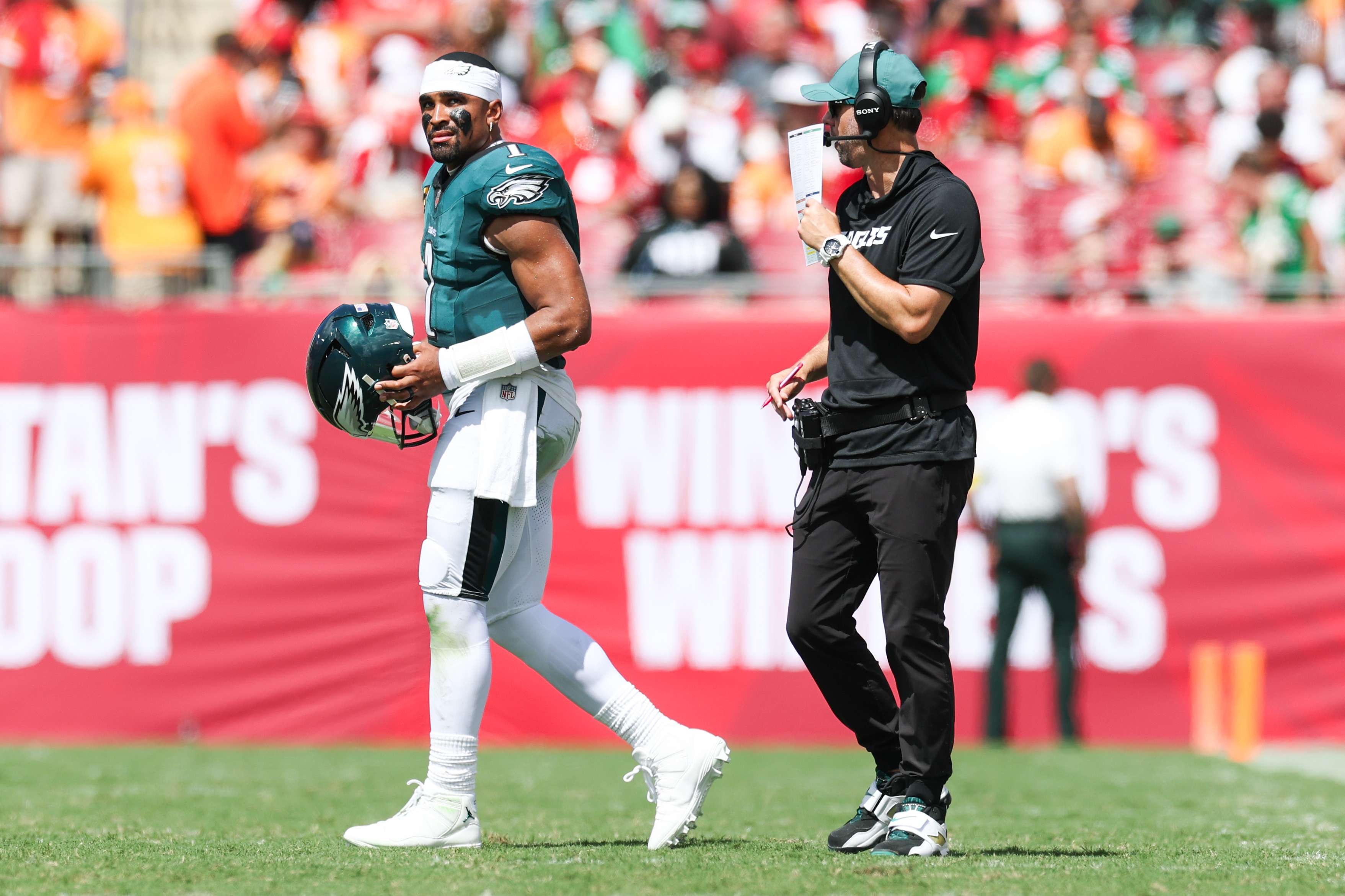 Sep 28, 2025; Tampa, Florida, USA; Philadelphia Eagles offensive coach Kevin Patullo communicates with quarterback Jalen Hurts (1) during a timeout in the second quarter against the Tampa Bay Buccaneers at Raymond James Stadium. Mandatory Credit: Nathan Ray Seebeck-Imagn Images